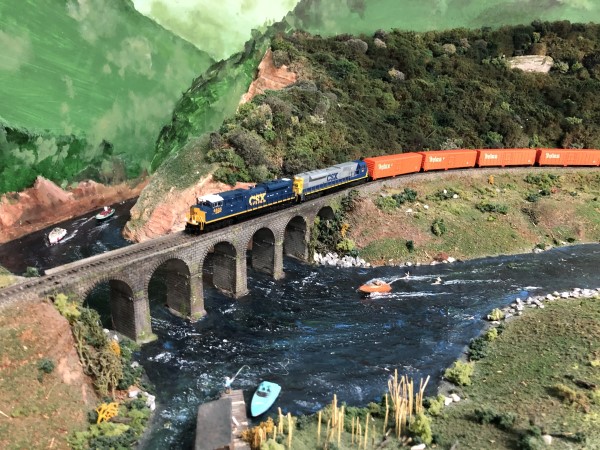 A century old bridge groans as a modern manifest train rumbles across it